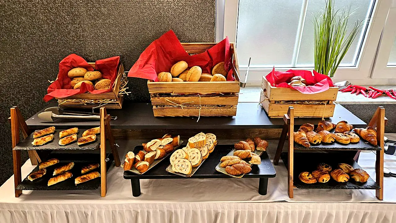 Auslage mit frischen Brötchen, Baguette und Croissants in Holzkisten