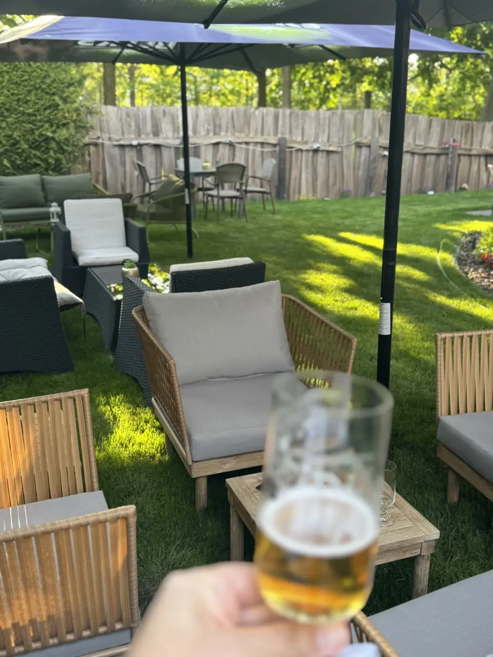 Gemütliche Sitzecke mit Kissen unter Sonnenschirmen im Garten